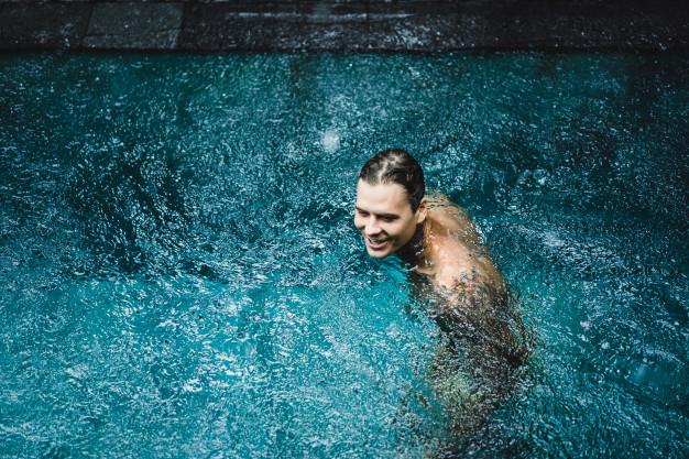 Hombre bañándose en una piscina cubierta