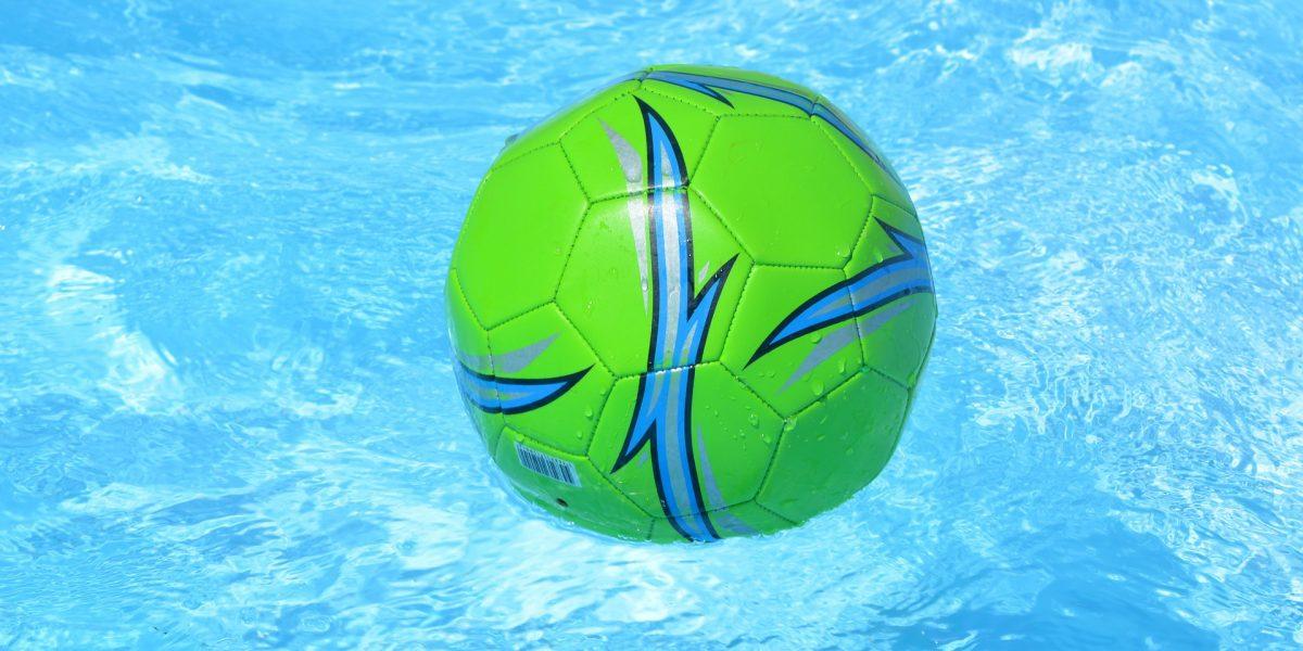 Pelota de color verde flotando en una piscina