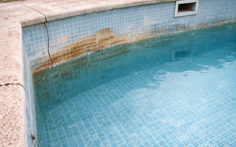piscina de obra deteriorada con manchas en el gresite