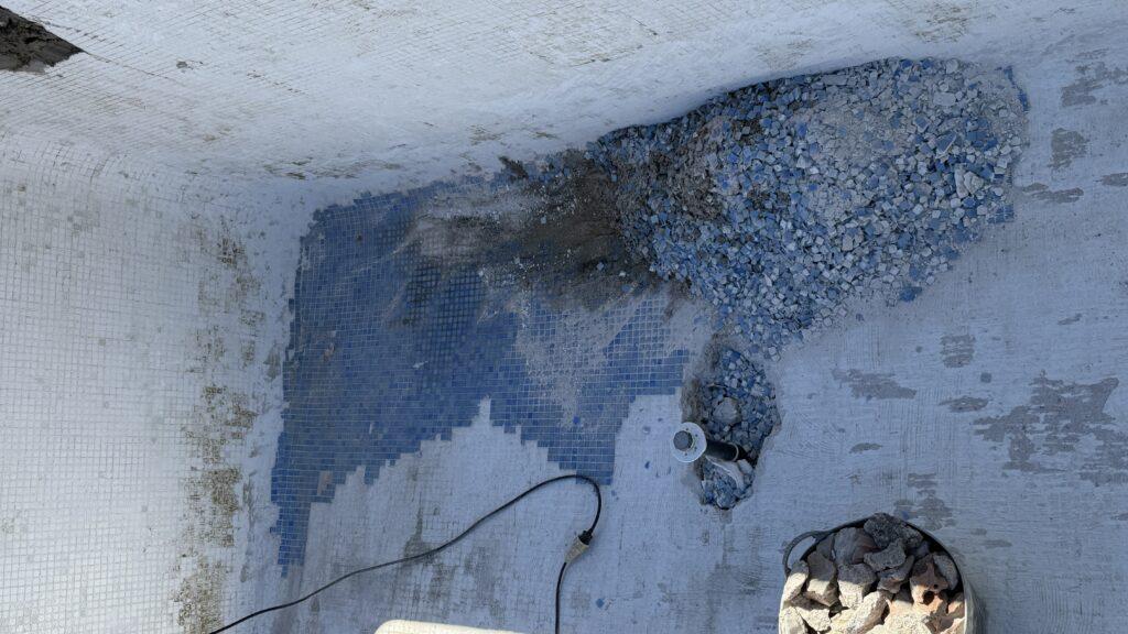 Piscina con gresite deteriorado y zonas dañadas antes de una rehabilitación completa